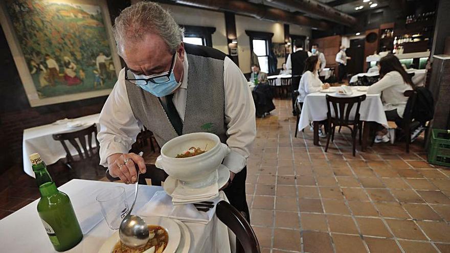 Camarero sirviendo el menú en  un restaurante en 2020. | Miki López