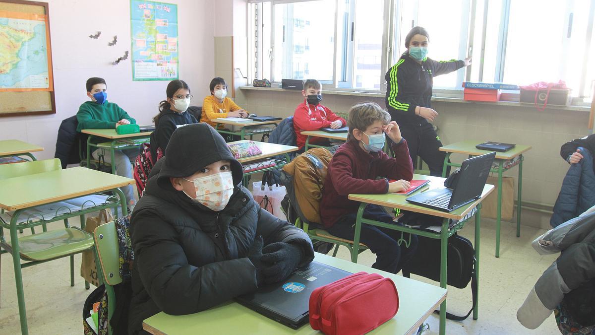 Una alumna abre la ventana en una de las aulas del CEIP Mestre Vide.