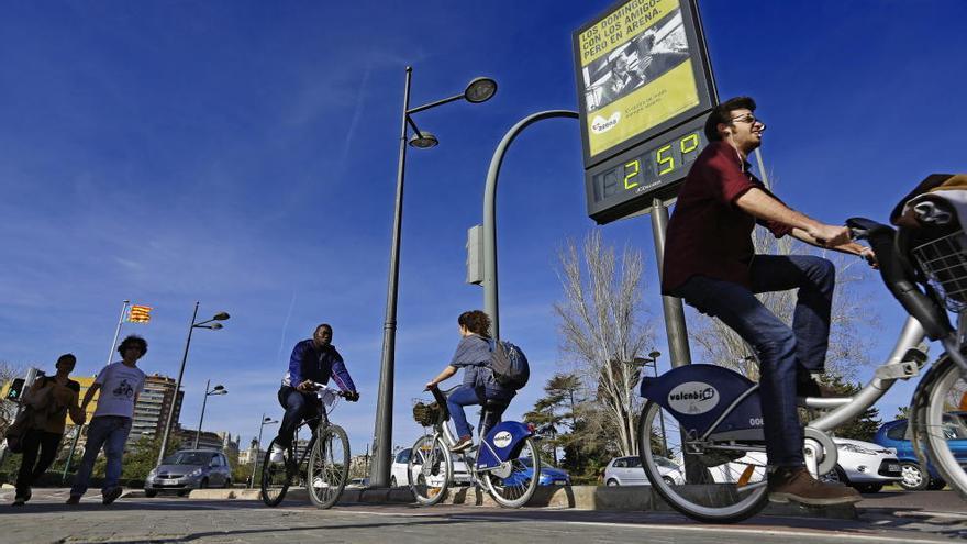 Varios usuarios, por las calles de Valencia en bici.