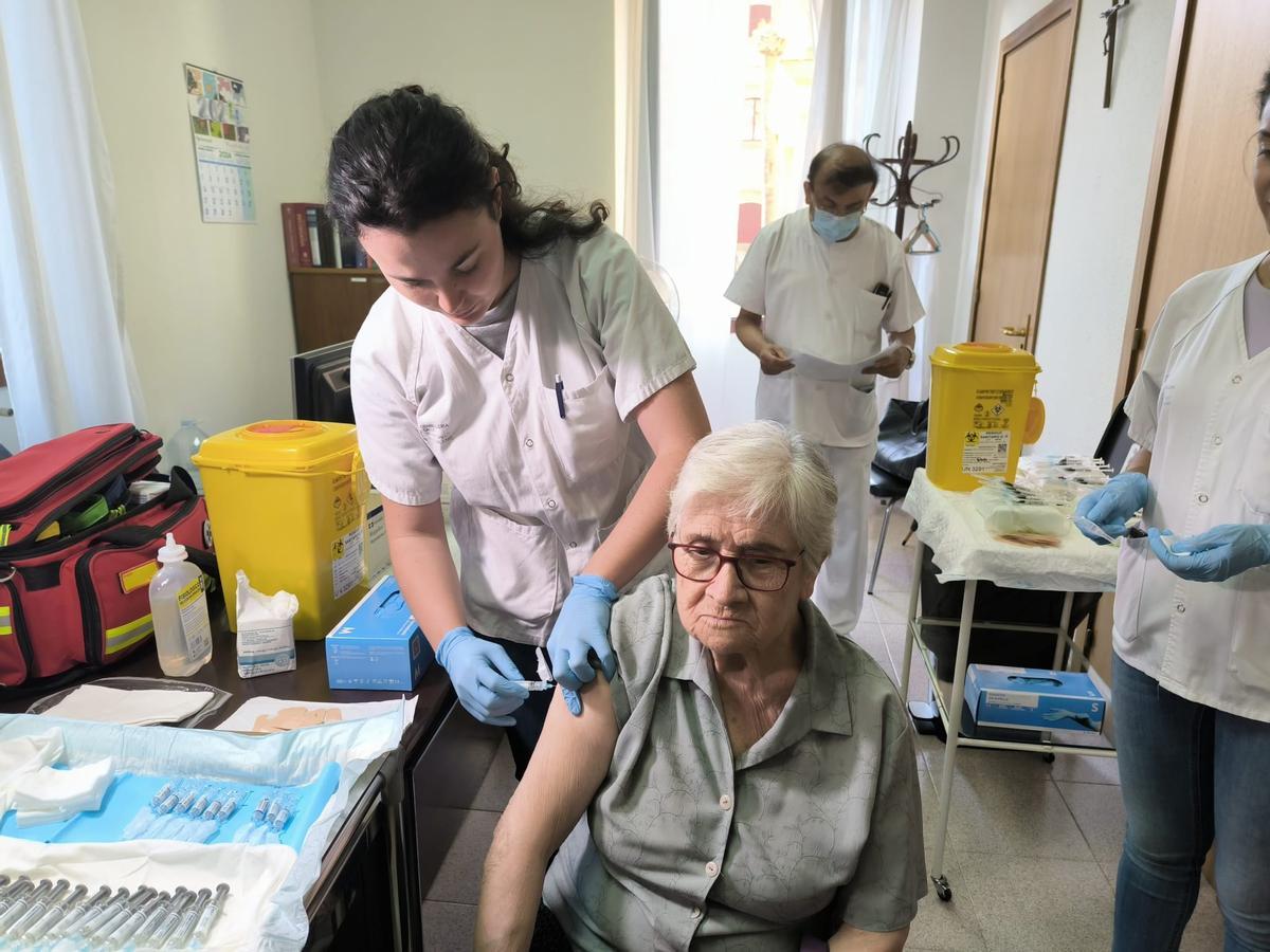 Una enfermera vacuna de la gripe a una mujer.