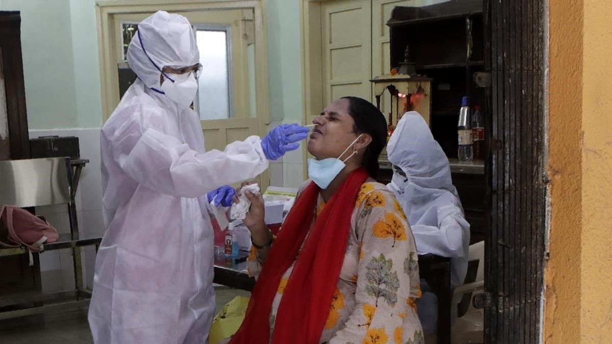 Un sanitario realiza un test de coronavirus a un trabajador en la India.