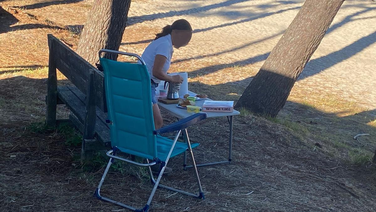 Una autocaravanista poniendo la mesa a pie de playa.