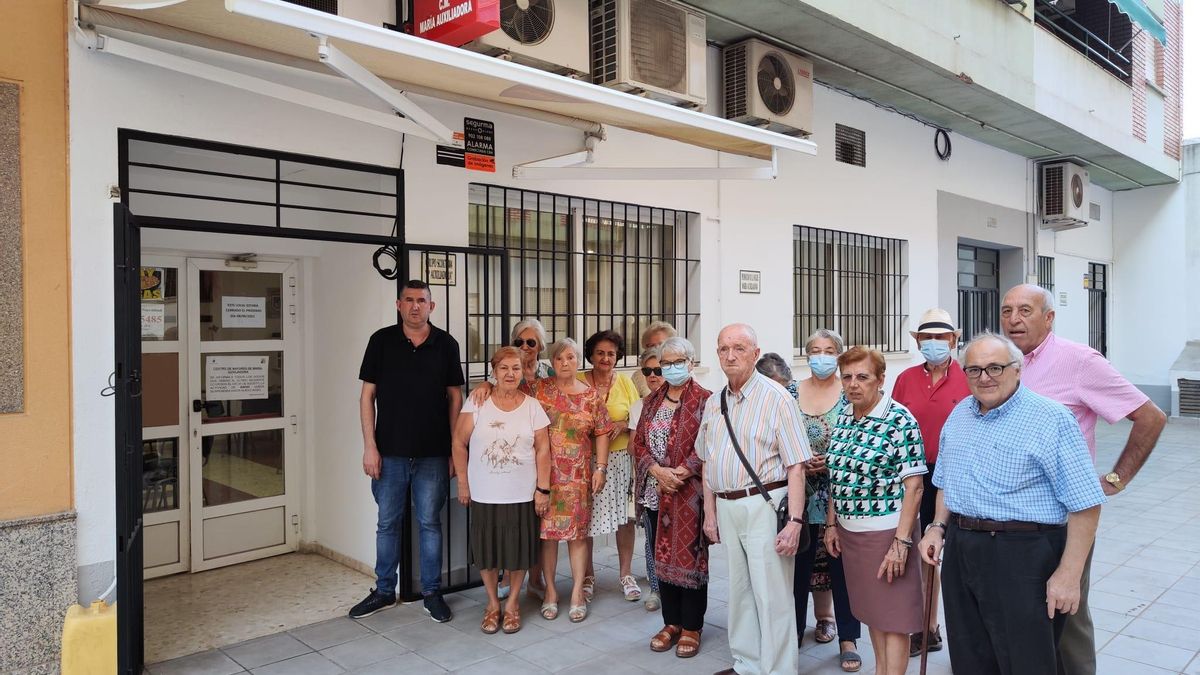 Usuarios y camarero a las puertas del centro de mayores de María Auxiliadora sin poder jugar.