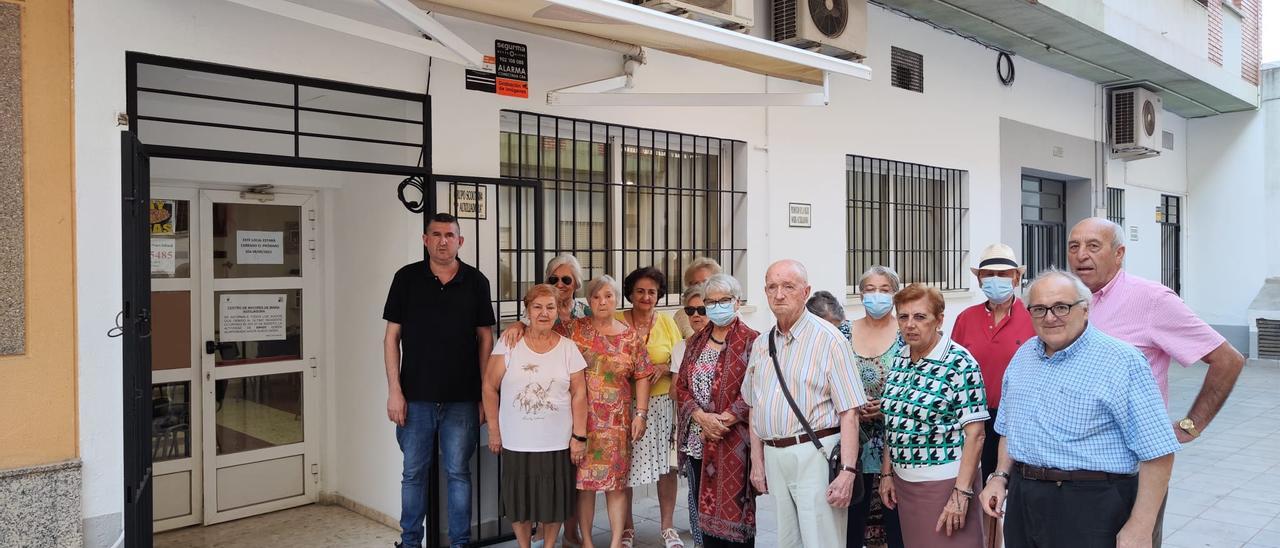 Usuarios y camarero a las puertas del centro de mayores de María Auxiliadora sin poder jugar.