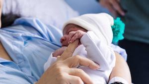 El bebé Erik, el primer madrileño en nacer en 2024, descansa sobre su madre, María Liz.,