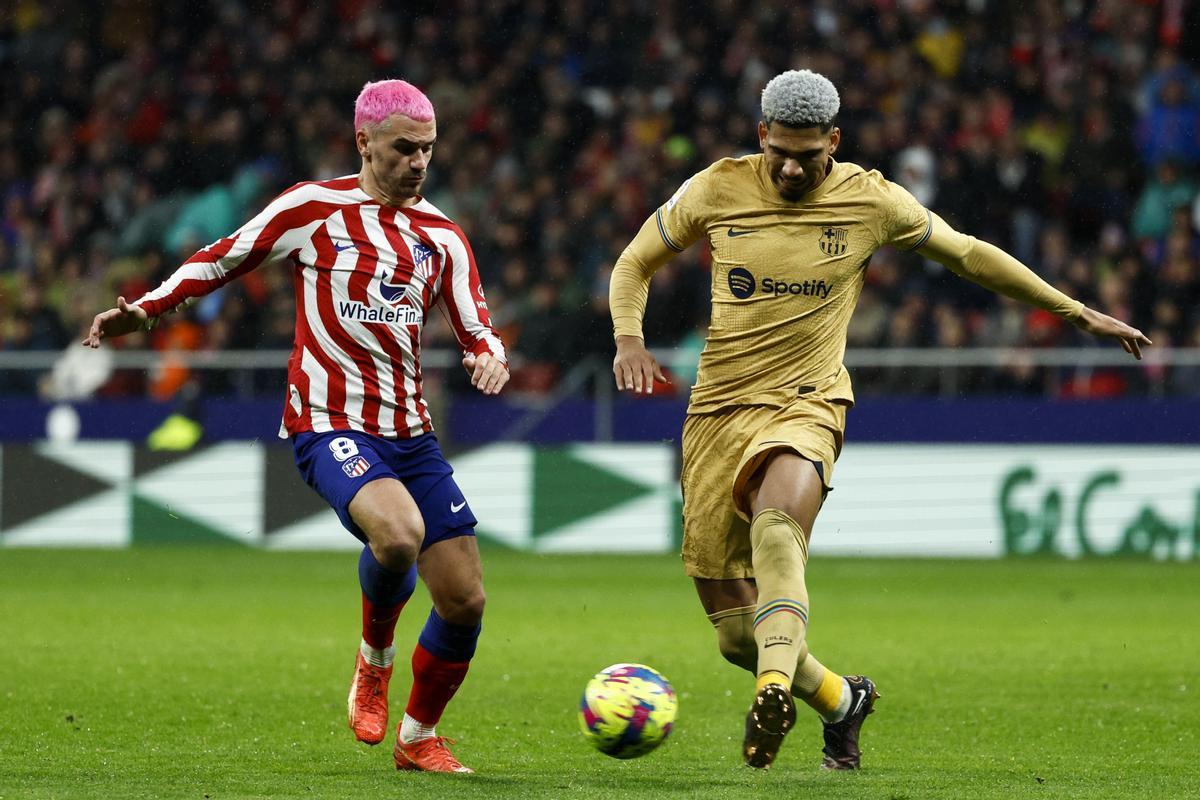 MADRID, 08/01/2023.- El delantero francés del Atlético de Madrid ANtoine Griezmann (i) con el balón ante Ronald Araújo, del FC Barcelona, durante el encuentro correspondiente a la jornada 16 de primera división que disputan hoy domingo ante el Atlético de Madrid en el estadio Metropolitano, en Madrid. EFE / Rodrigo Jimenez