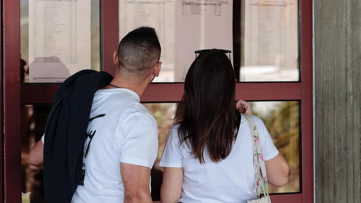 Dos aspirantes al MIR en Santa Cruz de Tenerife miran las listas para los exámenes.