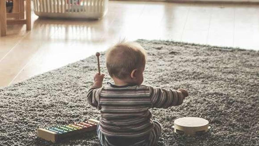 Un bebé jugando en el salón de su casa.