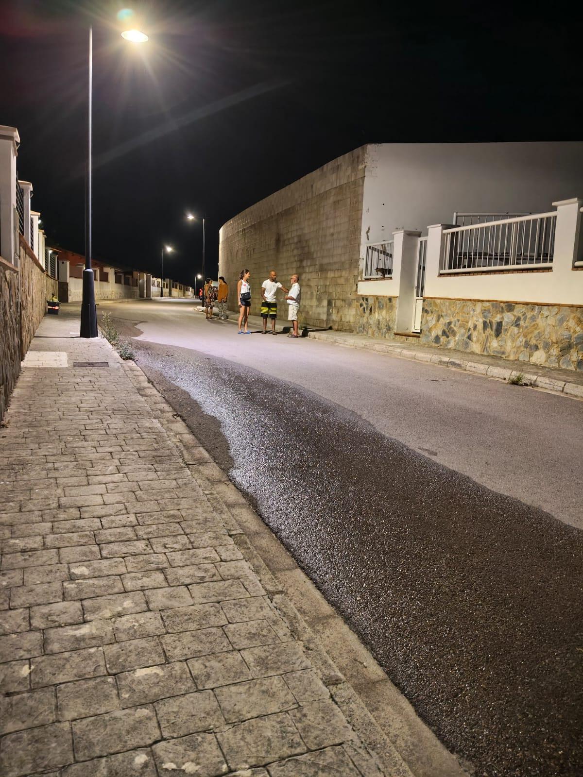 Algunos vecinos pasean por las calles iluminadas.
