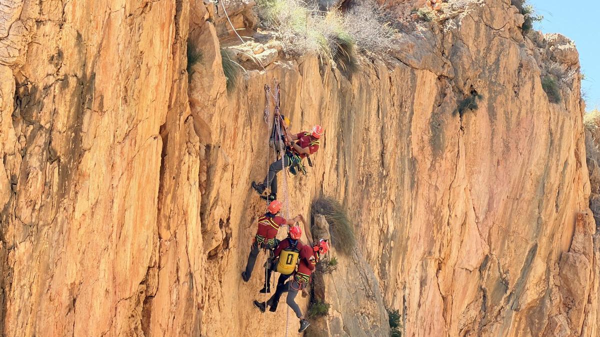 Los rescatadores, colgados en la imponente pared vertical de la Falla del Moraig