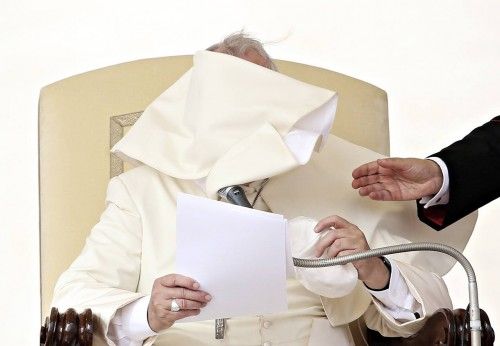 Una ráfaga de viento sopla manto del Papa Francisco mientras dirige a su audiencia semanal en la Plaza de San Pedro en el Vaticano