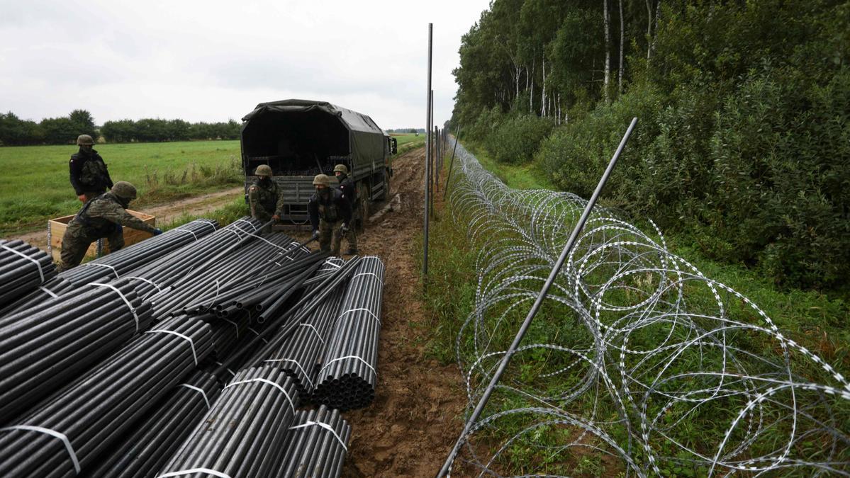 Soldados polacos descargan material para construir una valla en la frontera con Bielorrusia, el pasado 26 de agosto.