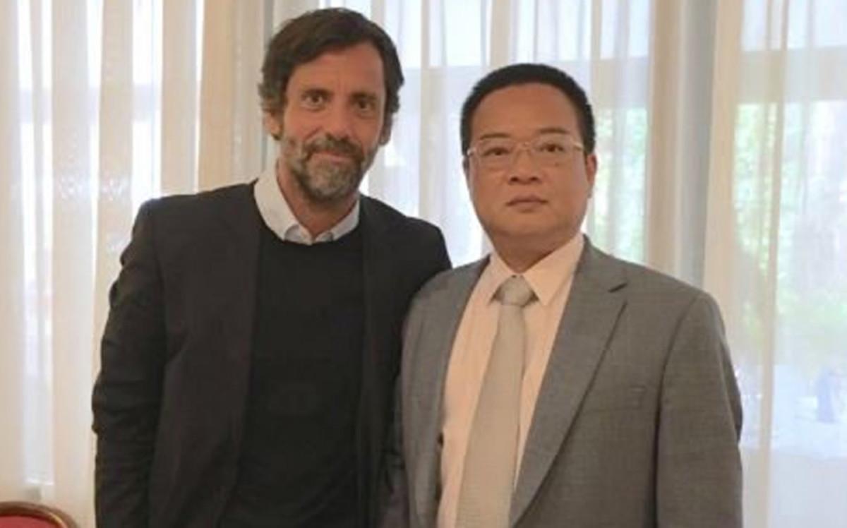 Quique, junto a Chen, tras firmar el acuerdo