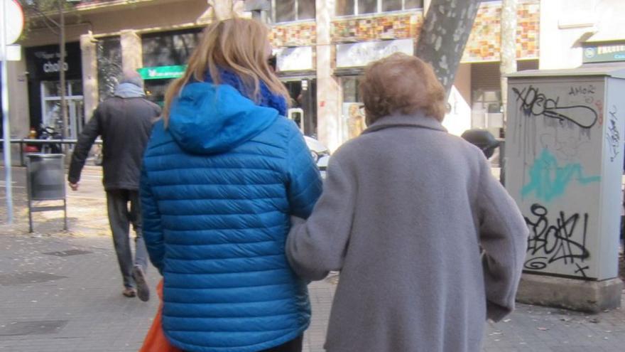 Una cuidadora acompaña a una anciana dependiente. |   // EP