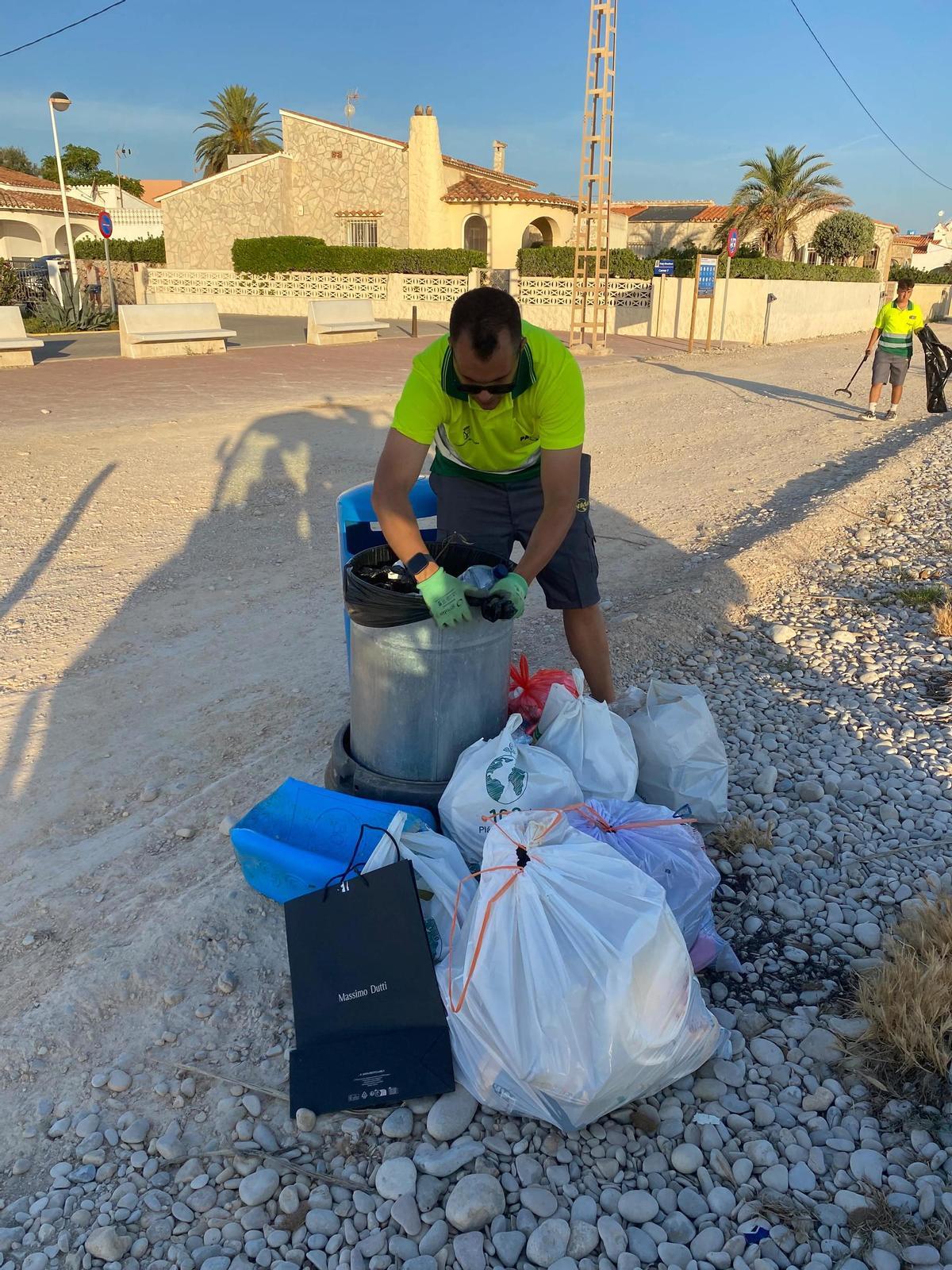 Un operario recoge las bolsas de basura abandonadas junto a las papeleras