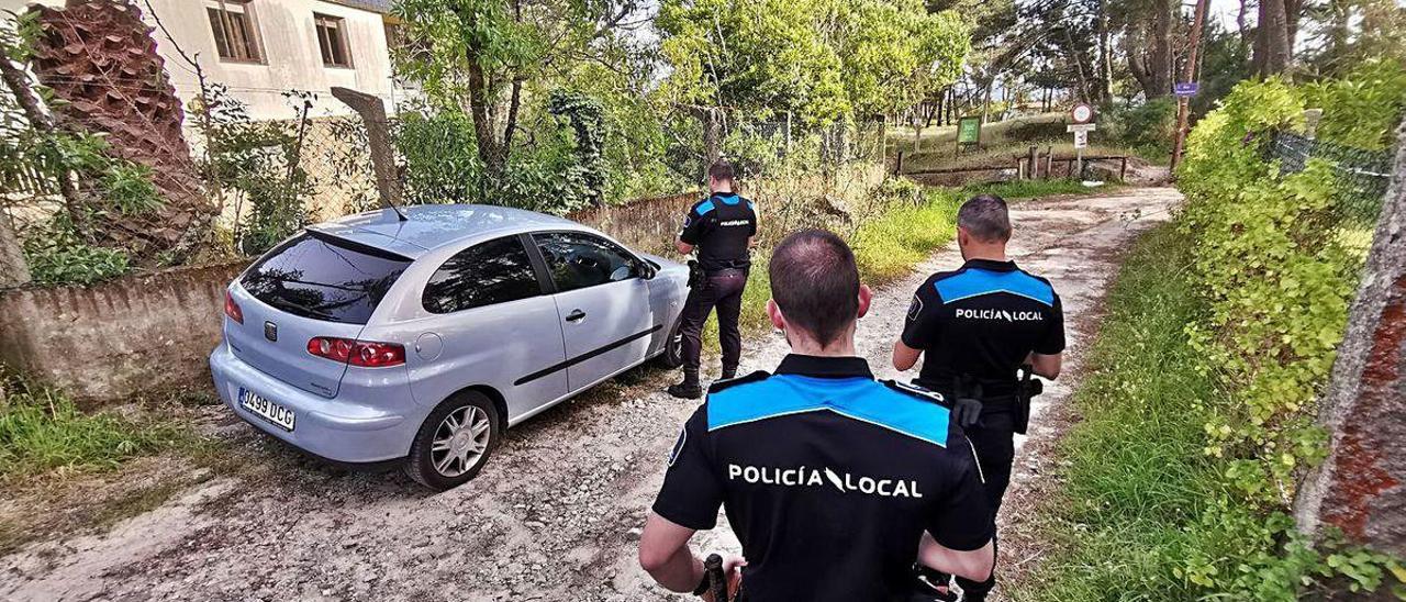 Agentes de la Policía Local de Cangas inspeccionan un coche en el entorno de la playa de Viñó.