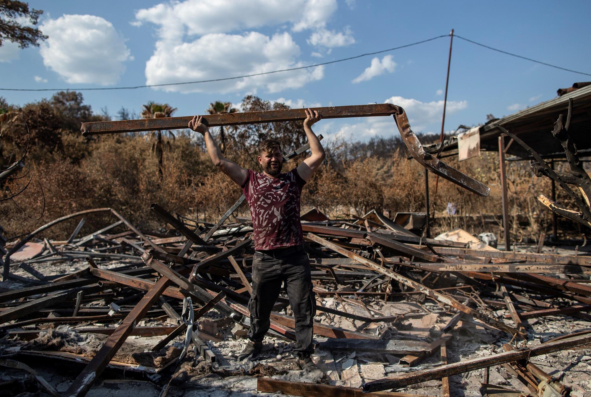 El trabajador de un centro turístico en el sur de Turquía devastado por las llamas muestra los restos del lugar.