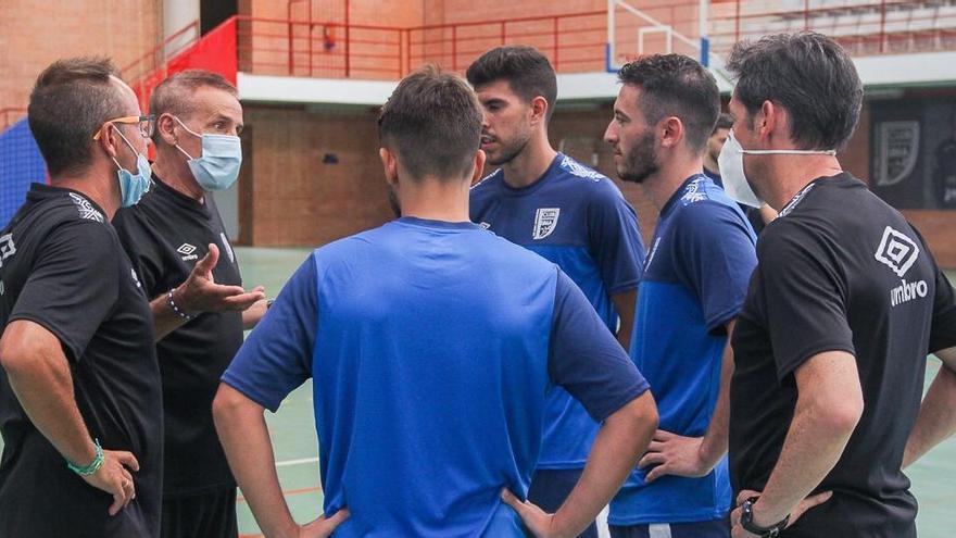 El cuerpo ténico del conjunto universitario hablando con los nuevos fichajes