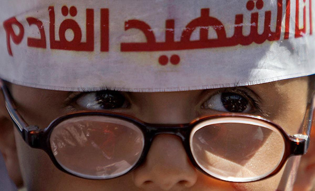 Un nen del Iemen porta una cinta al cap en què hi ha escrit: Sóc el pròxim màrtir. Un nen del Iemen porta una cinta al cap en què hi ha escrit: Sóc el pròxim màrtir.