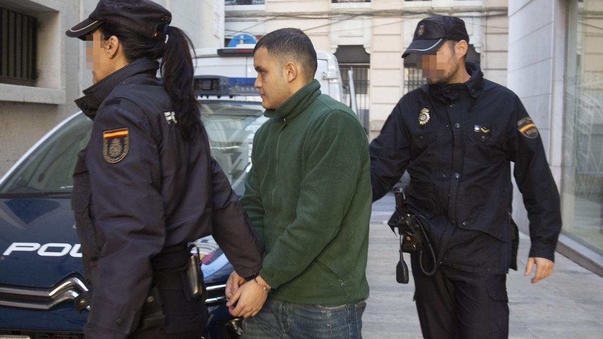 Dos policías nacionales trasladan al acusado de matar a un joven en La Vila Joiosa.