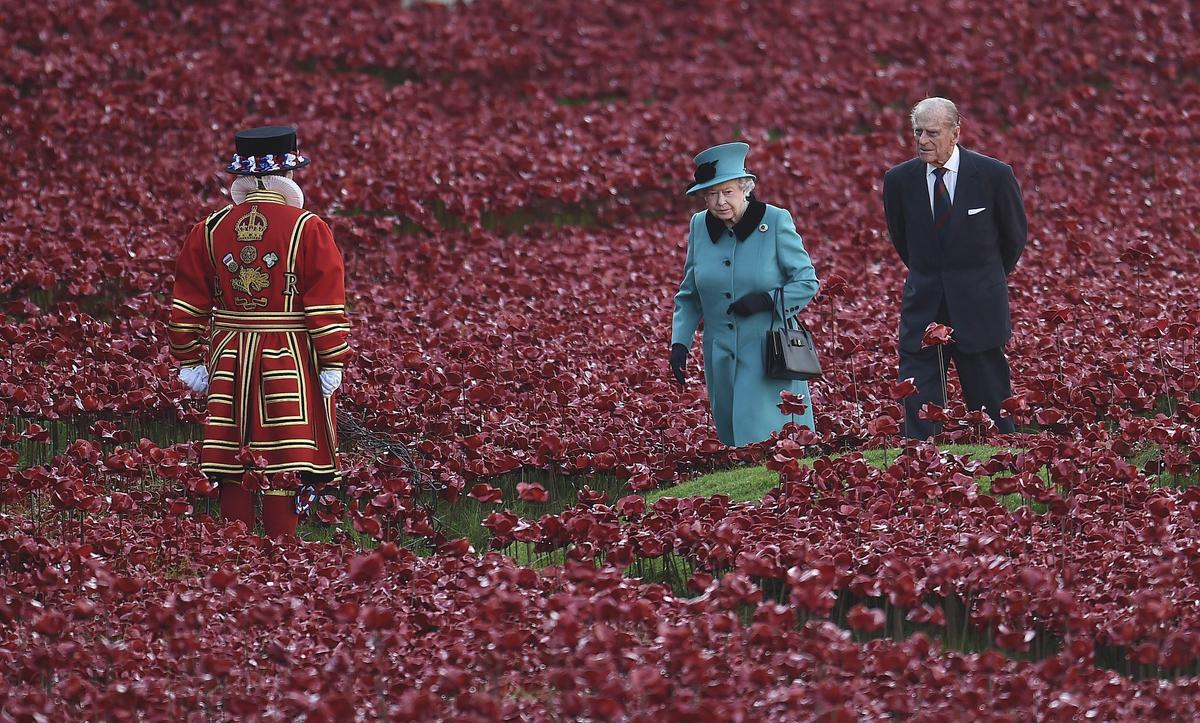 La reina Isabel II y el duque de Edimburgo  pasean entre las miles de &quot;Poppies&quot;, amapolas rojas de cerámica, plantadas en el foso de la Torre de Londres en octubre de 2014.