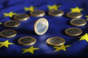 Archivo - FILED - 04 July 2011, Baden-Wuerttemberg, Karlsruhe: Euro coins lie on a Euro flag.