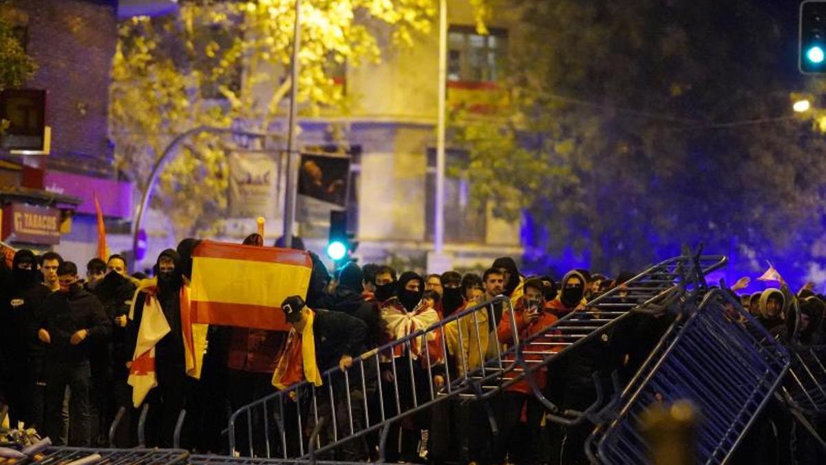 Jóvenes ultras desmontan la barrera policial durante el escrache a la sede socialista de la calle Ferraz de Madrid el 17 de noviembre