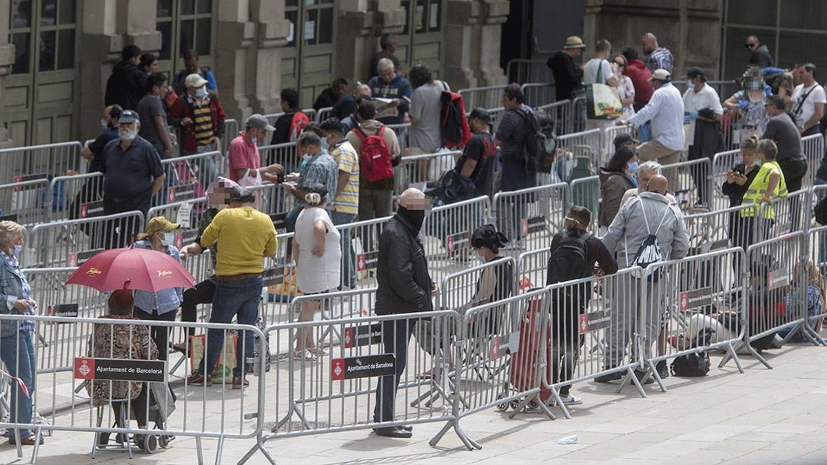 Cola ante la estación del Nord de Barcelona para el reparto de alimentos a familias necesitadas, el 16 de mayo