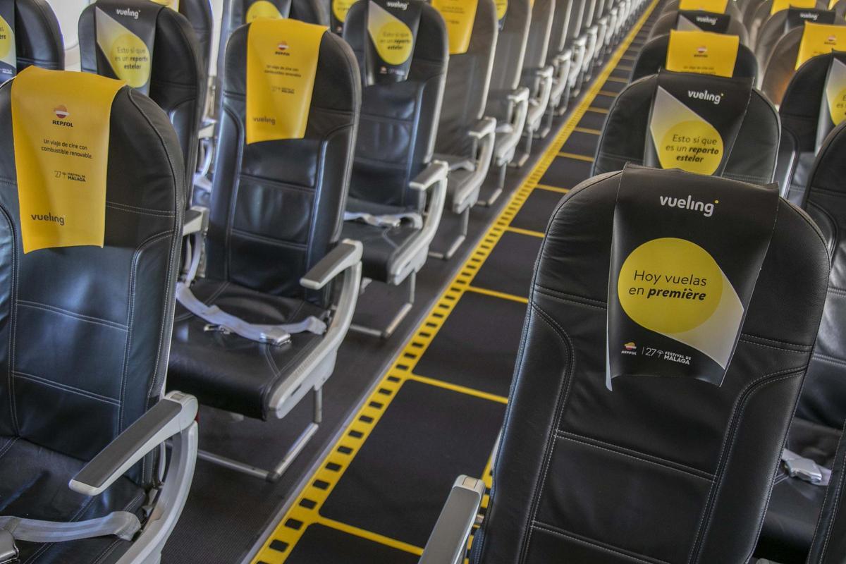 Interior del avión con reposacabezas especiales y una alfombra que emula el carrete de una película.