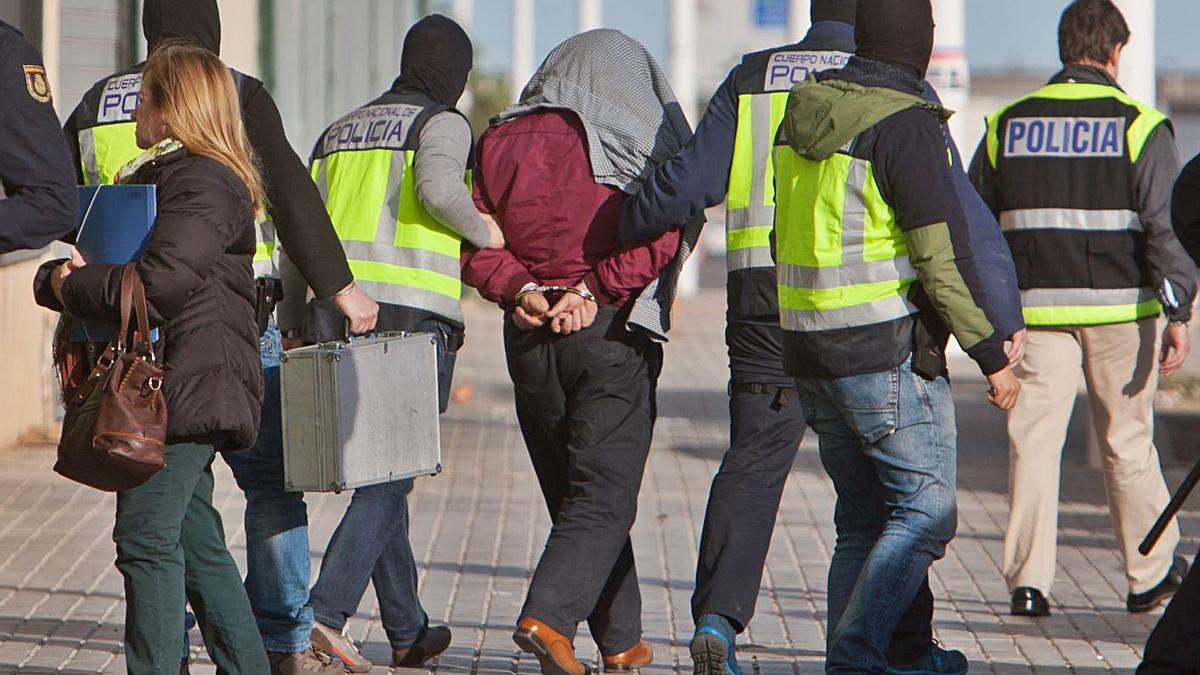 La Policía Nacional conduce a uno de los detenidos en Crevillent el día de la operación. | SERGIO FERRÁNDEZ