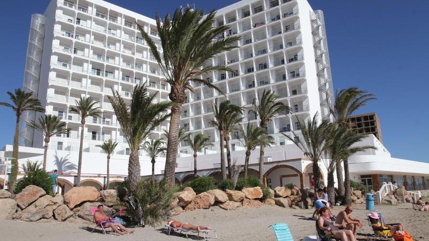 Varios turistas toman el sol frente a su hotel en La Manga.