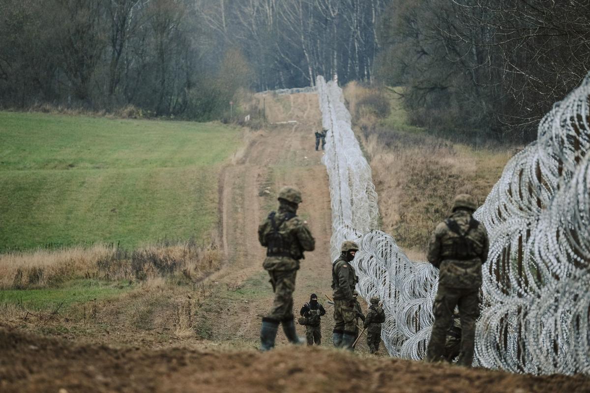 Soldados del ejército polaco arreglan bobinas de alambre de púas en una valla a lo largo de la frontera polaca, con el enclave ruso de Kaliningrado, cerca de Zerdziny, Polonia