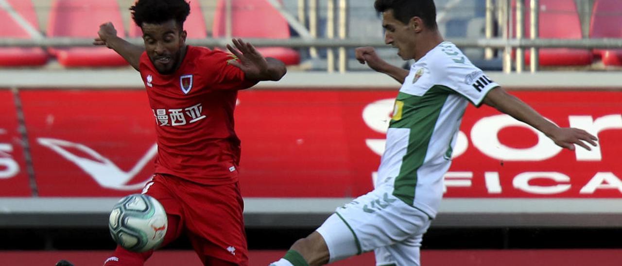 Pere Milla, que fue una de las novedades en el once inicial del Elche frente al Numancia, pugna por un balón con Derik.