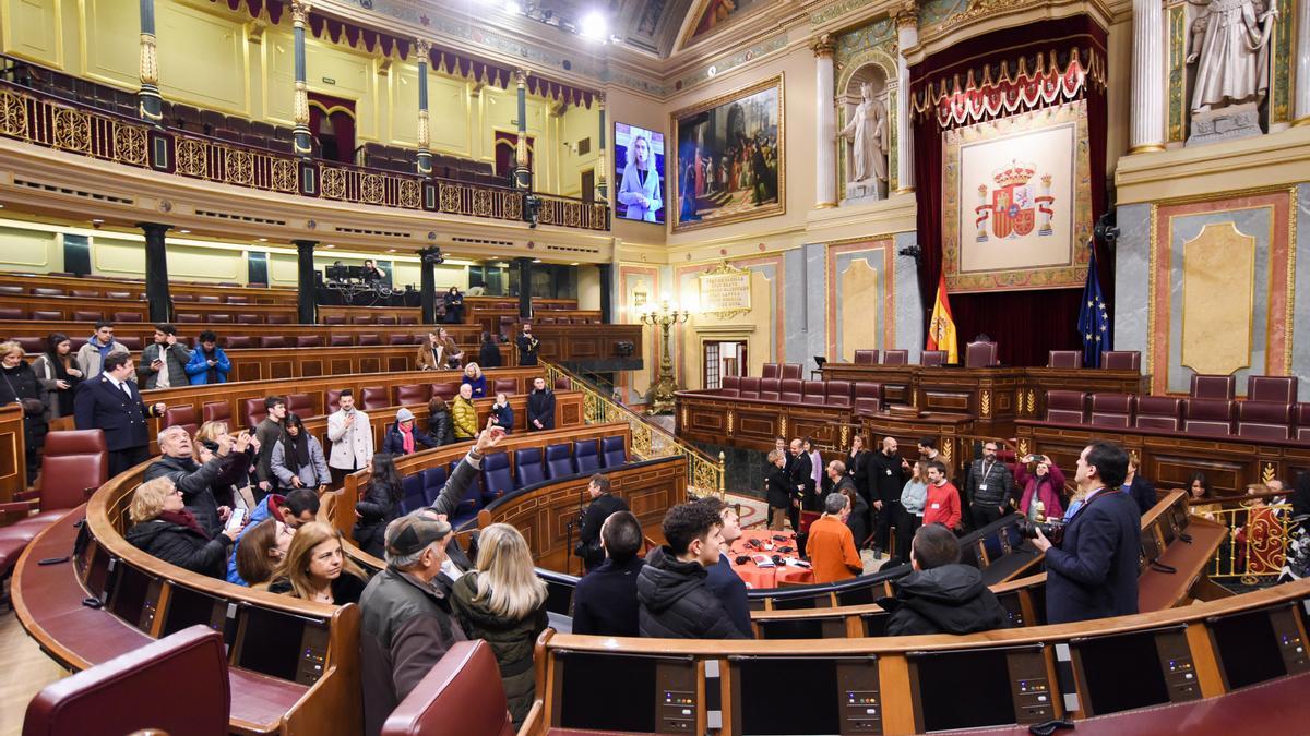 Un grupo de personas en el hemiciclo del Congreso de los Diputados durante la jornada de puertas abiertas.