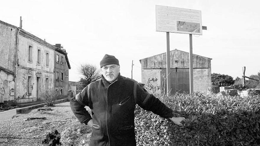 Ángel Varela, ayer, con la vivienda donde reside a la izquierda, en el alto de Aboño.