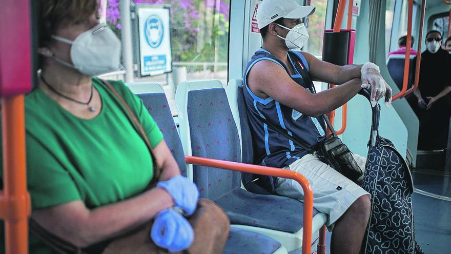 Varias personas con mascarilla, en el tranvía.