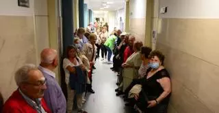 Mayores de 80 años esperan para vacunarse en el centro de salud de Cangas más de una hora, en un pasillo sin sillas