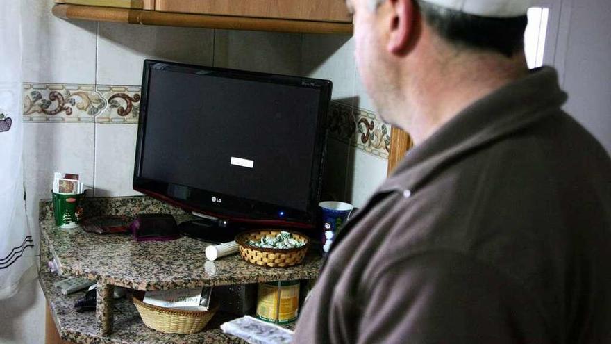 Un vecino de Castro de Arriba, ayer, intentando sintonizar la televisión en su domicilio. // Bernabé/Luismy