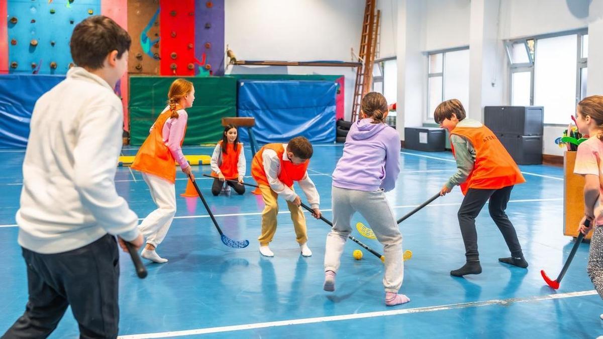 Niños jugando al hockey en un colegio.