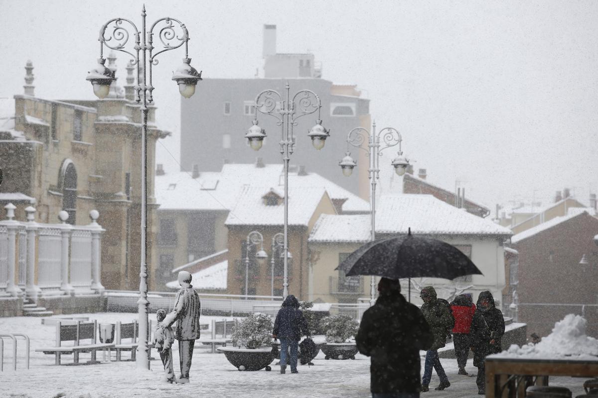 Varias personas pasean por la calle mientras nieva, a 18 de enero de 2023, en León, Castilla y León (España). La Agencia Estatal de Meteorología (Aemet) ha activado la alerta naranja en las zonas de la Cordillera Cantábrica y el Bierzo. En la montaña se e