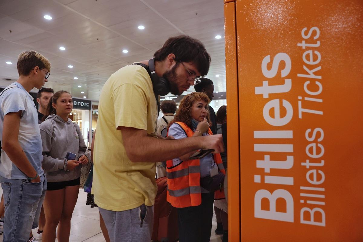 Usuarios comprando billetes de Rodalies en la estación de Sants