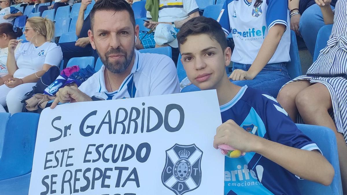 Unos aficionados sostienen un cartel crítico hacia Garrido.