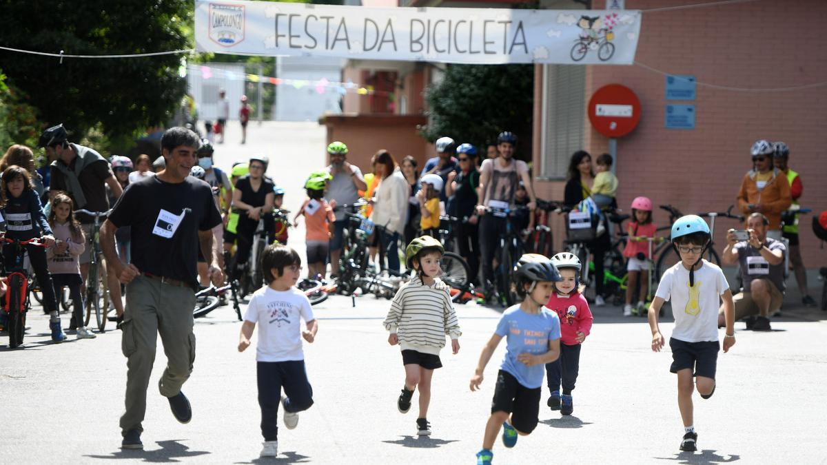 Unos pequeños corren a coger sus bicicletas.