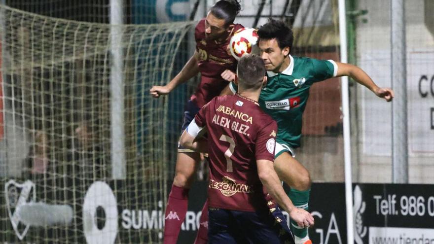 Un jugador del Coruxo salta a por el balón durante el partido con el Pontevedra.  |  José Lores