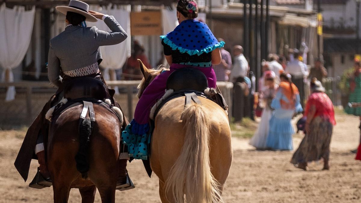 Dos caballistas cabalgan por la aldea almonteña de El Rocío (Huelva)