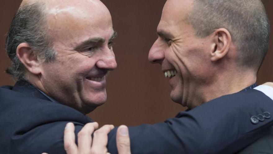 Abrazo entre Guindos y Varufakis antes de la reunión.