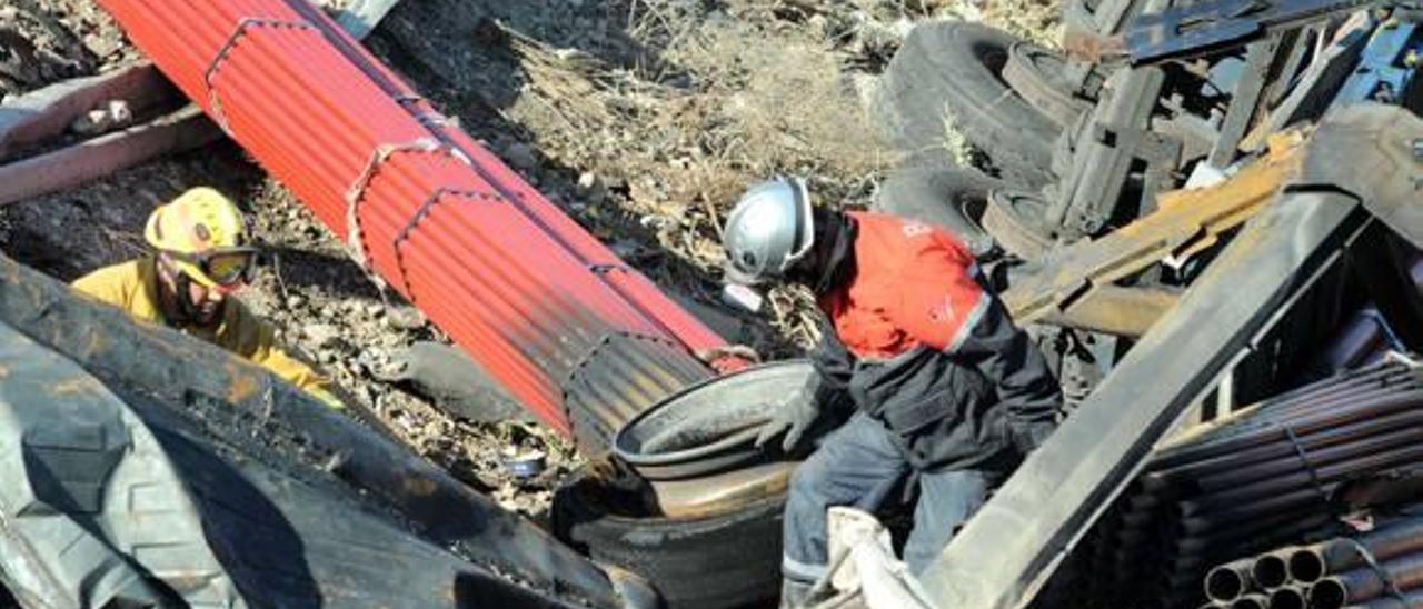 Un bombero mira una de las ruedas del camión que sufrió un reventón y causó 8 muertos.