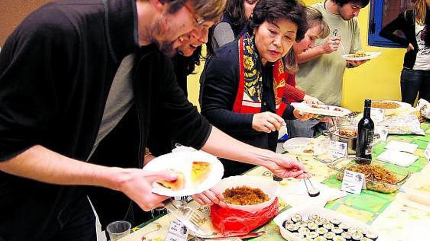 Los alumnos se sirven las distintas especialidades típicas de cada país en un momento de la fiesta.