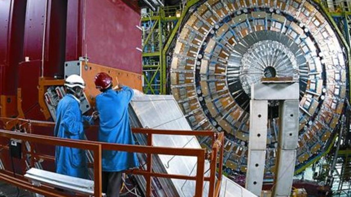 Dos ingenieros trabajan en acelerador de partículas del CERN.