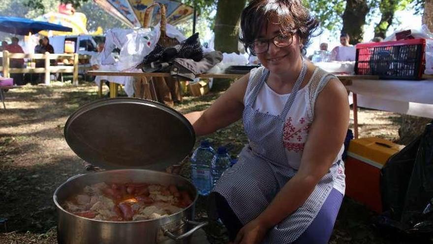 Una vecina una olla repleta de comida. // Bernabé/Gutier